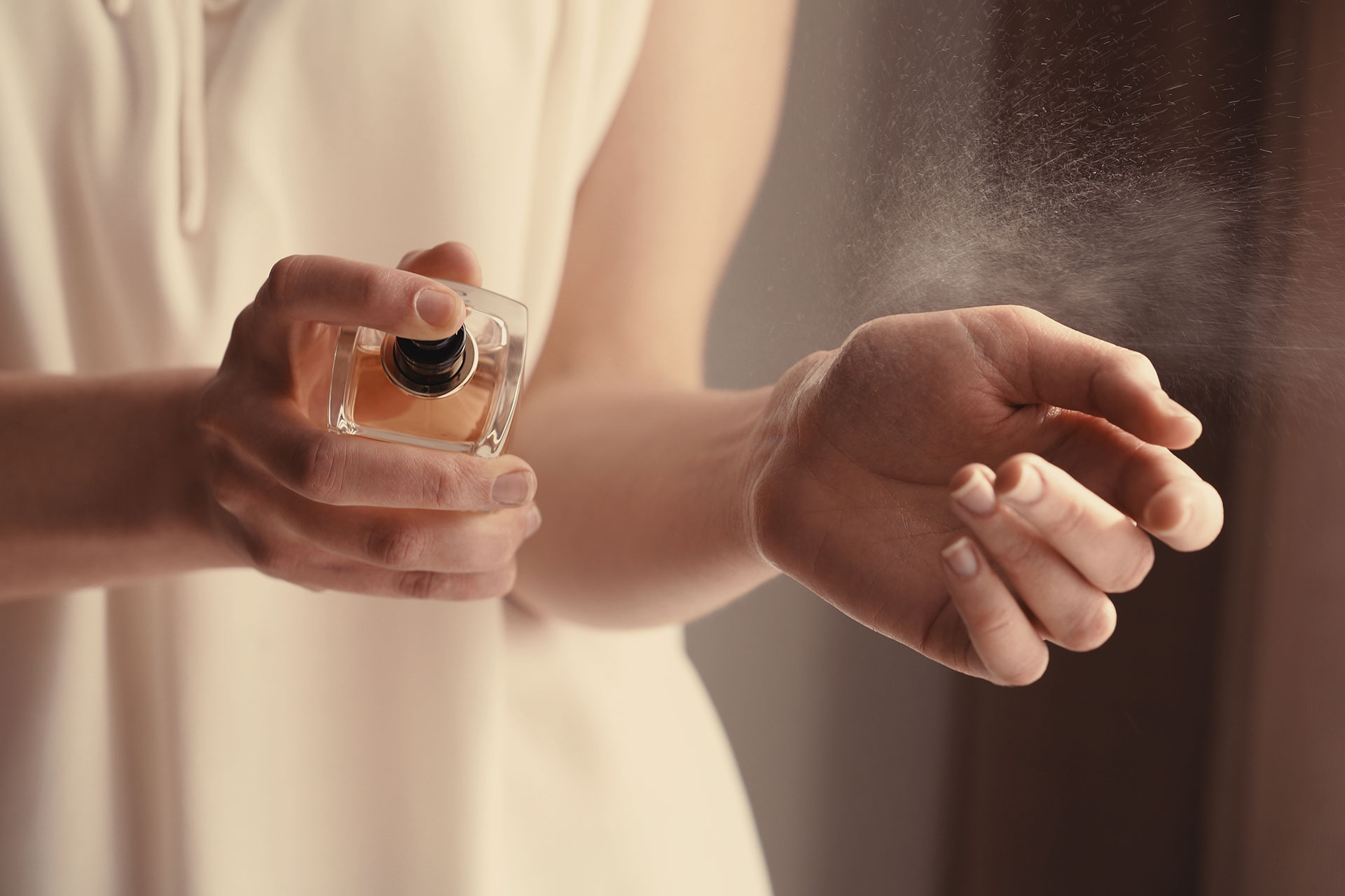 Woman Putting on Perfume; Courtesy of Africa Studio/Shutterstock.com